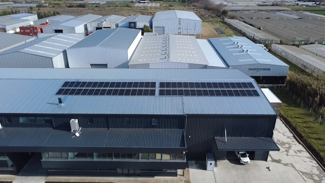 Vista aérea del depósito de MG Insumos en La Plata con paneles solares coplanares sobre la cubierta de chapa