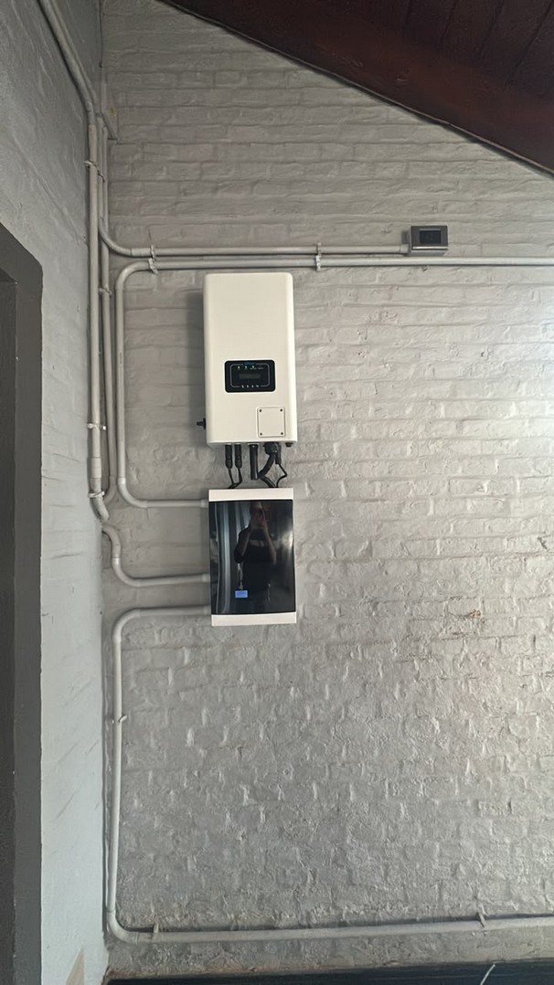 Inversor Deye trifásico de 10 kW instalado sobre una pared de ladrillo visto